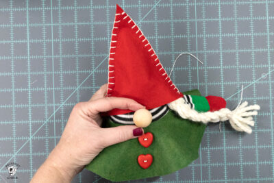 green circle of felt on gnome body with arm and braids and hat