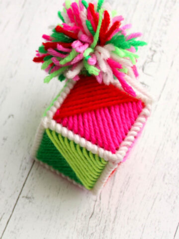 colorful yarn ornament on white wood table