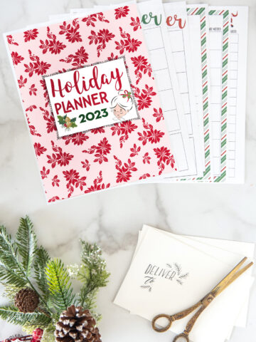 christmas planner pages on white marble table with pencils