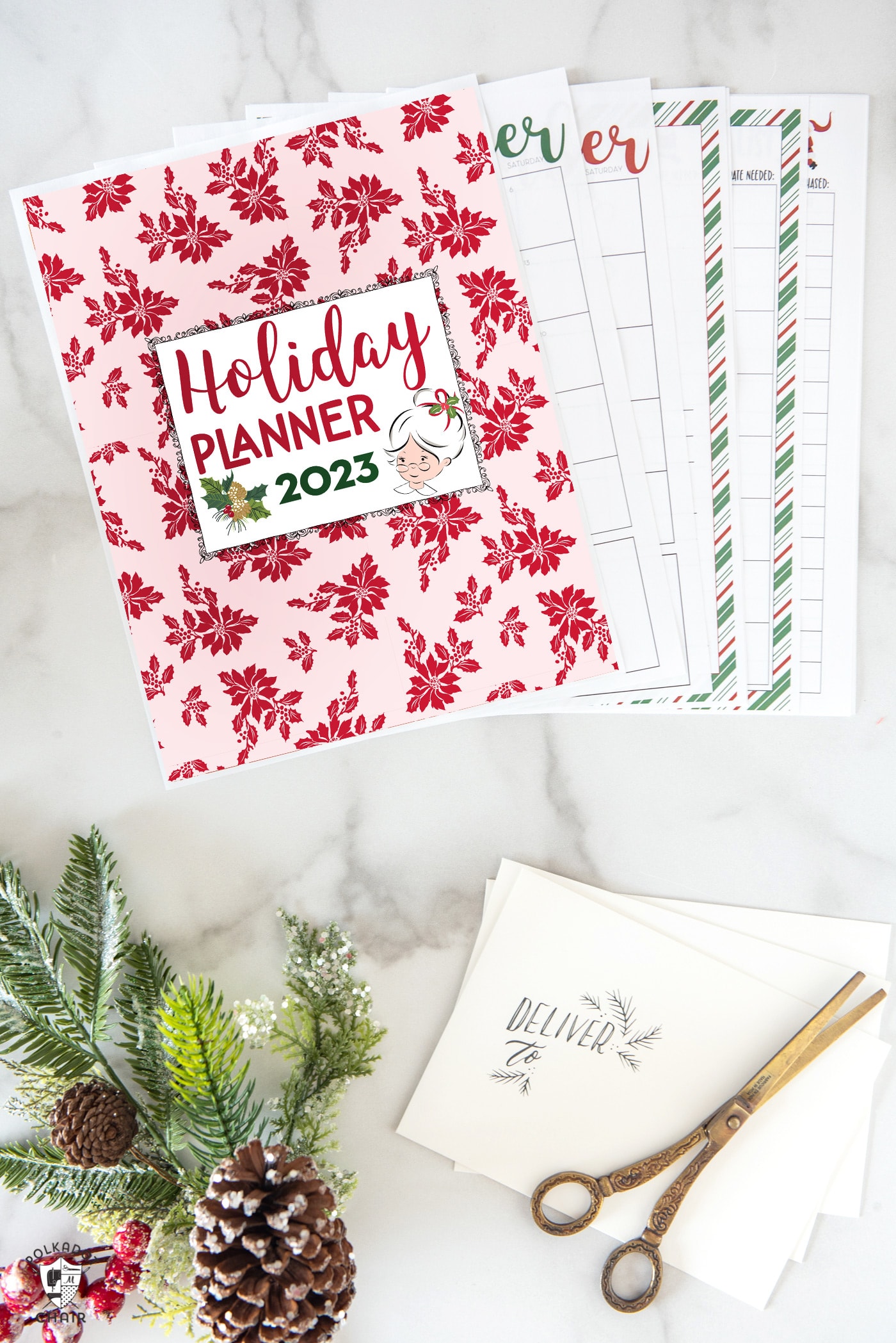 christmas planner pages on white marble table with pencils