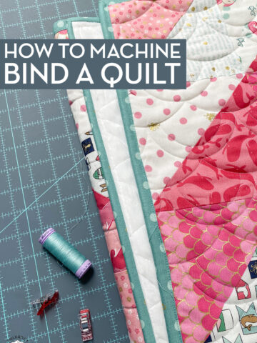 quilt, thread and clips on blue cutting mat