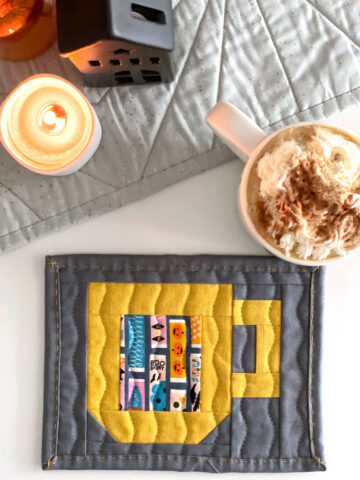 quilted mug rug pattern on table with cup of hot chocolate