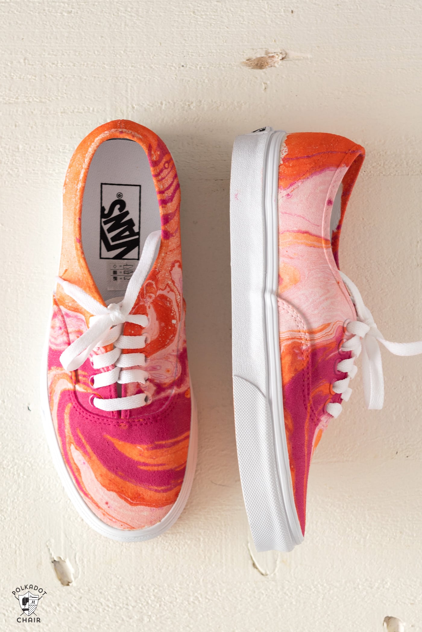 Pink orange and white marbled hydro dip vans on a piece of white foam.
