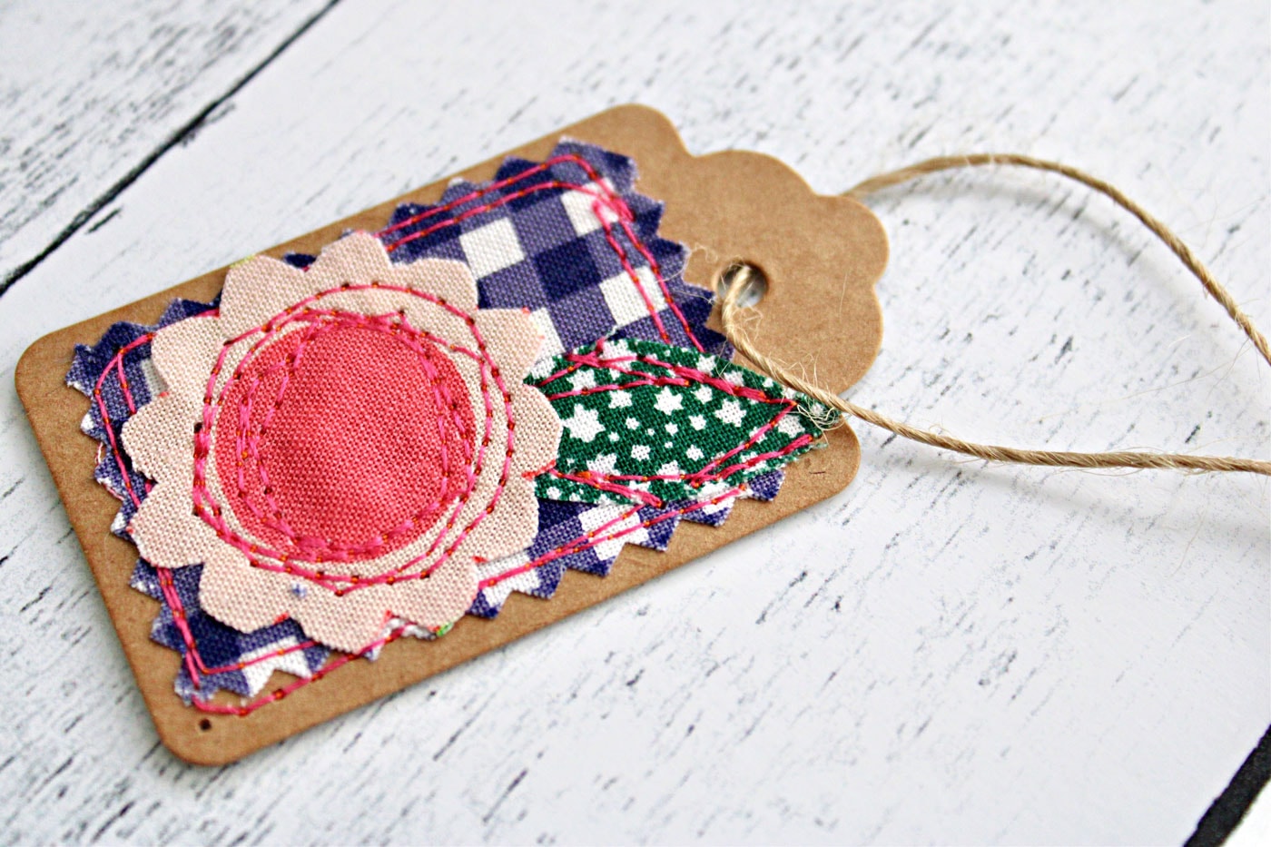 colorful fabric and paper gift tags on white wood table