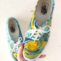 blue and yellow hydro dipped vans being held in hand