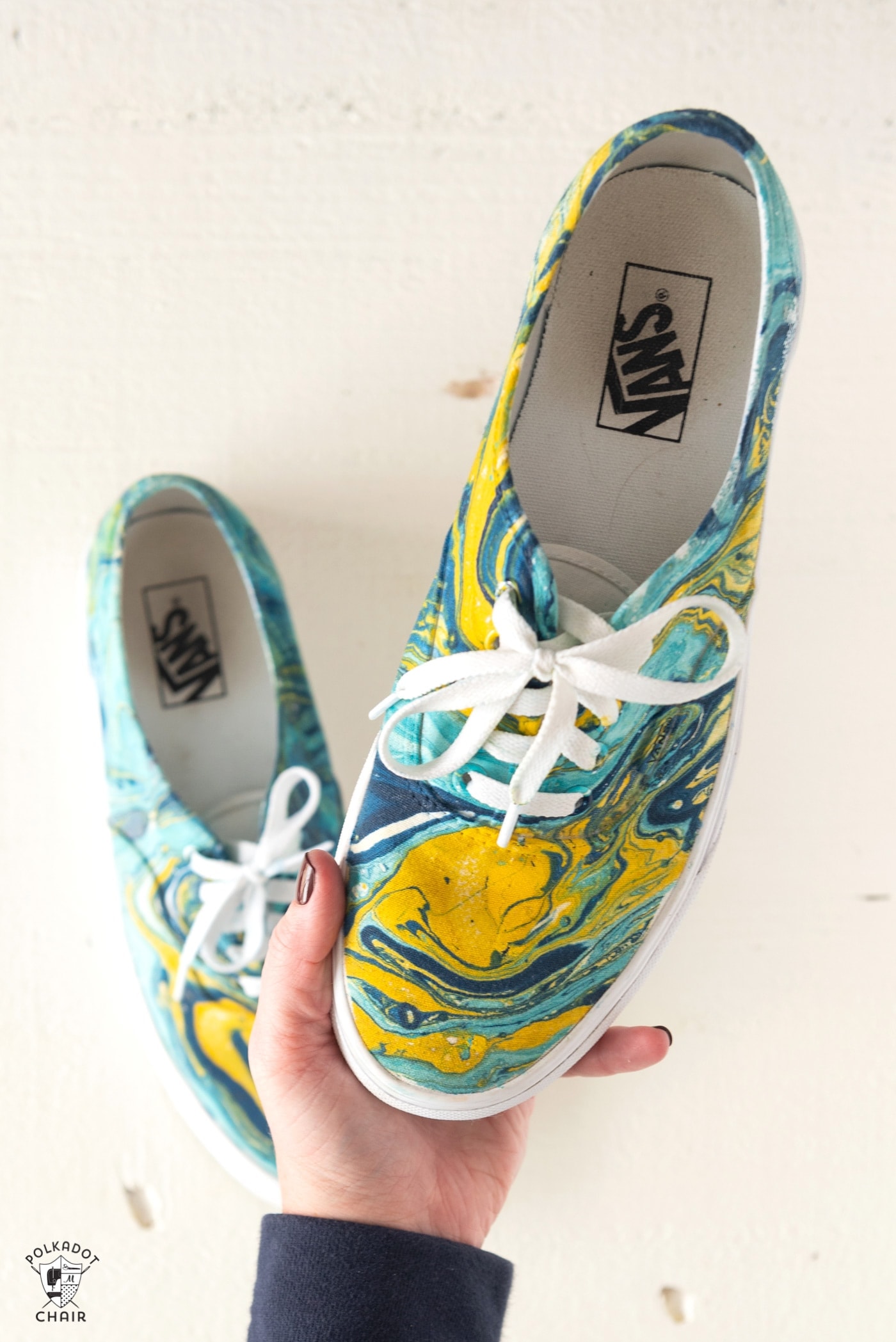 blue and yellow hydro dipped vans being held in hand