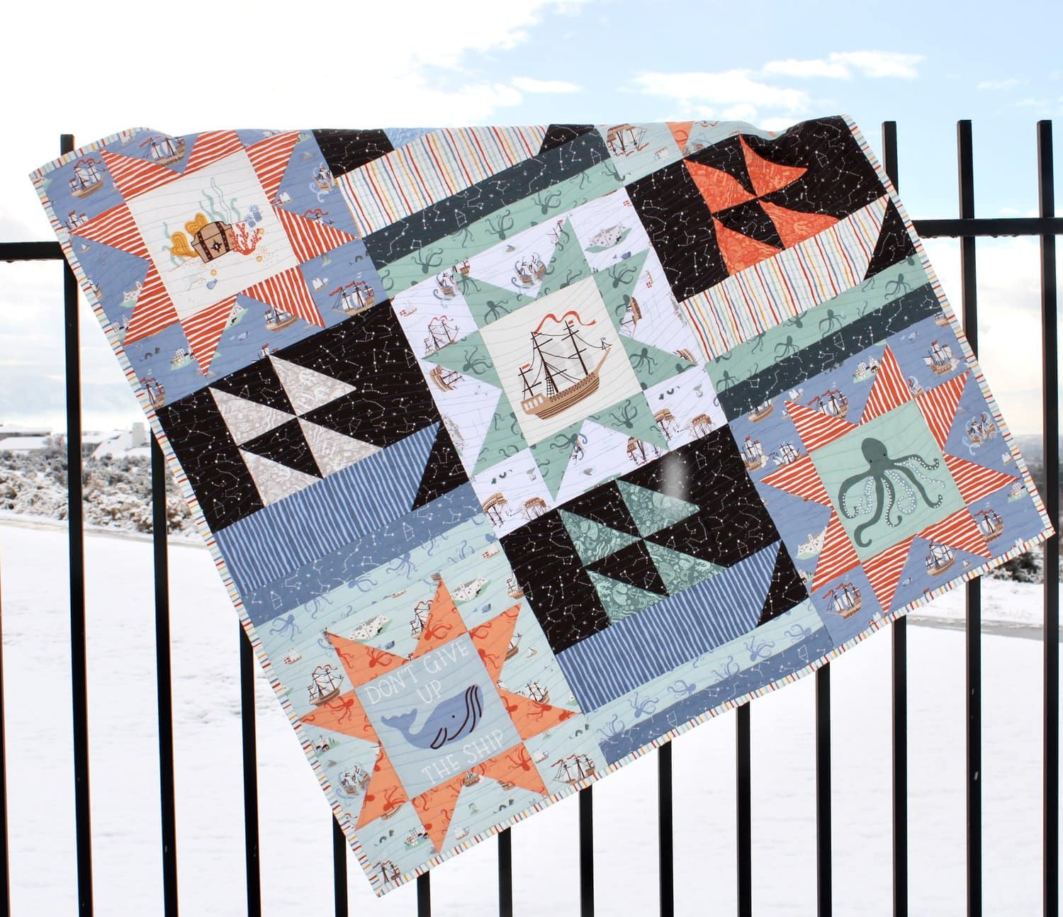 nautical quilt hanging on fence